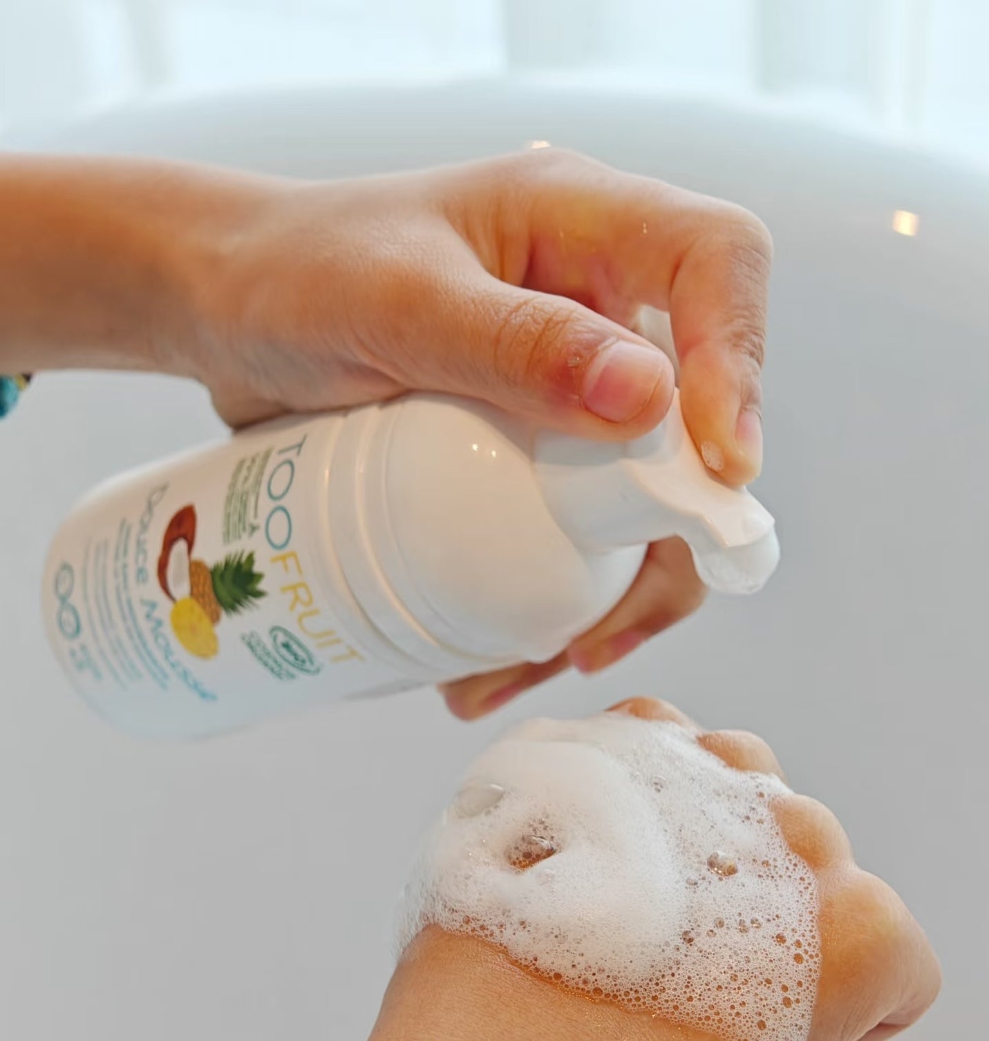a person pumping douce mousse foam on their hand
