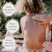 an adult applying toofruit sunscreen milk on boy's back
