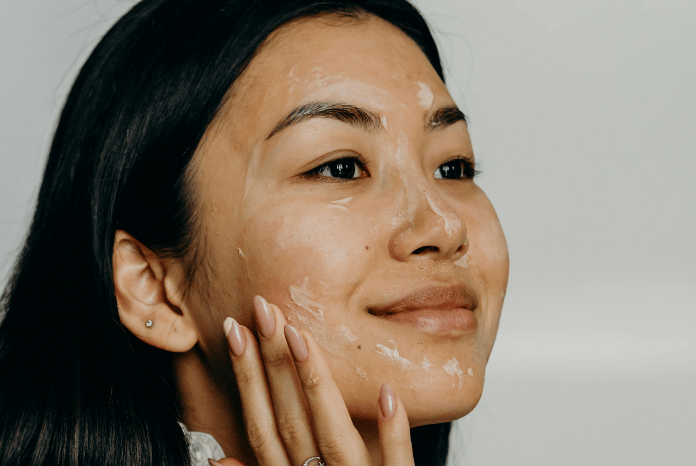 A woman using cream on her face