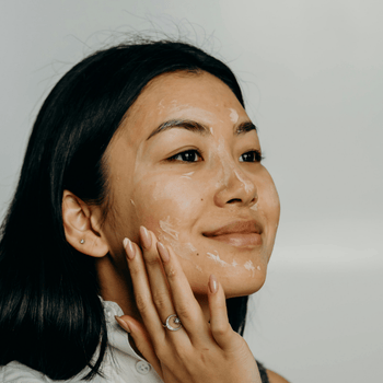 A woman using cream on her face