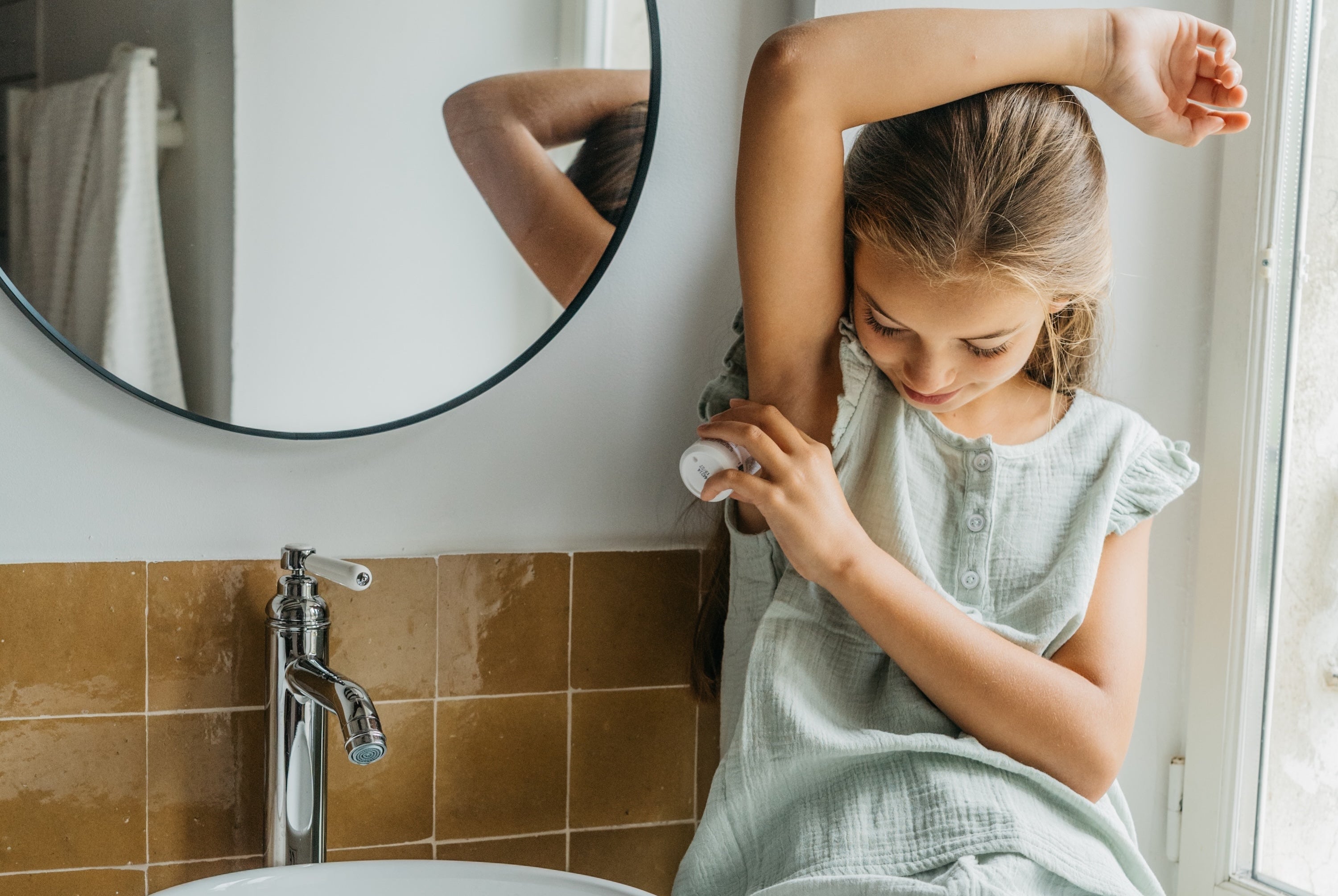 young girl applying deodorant