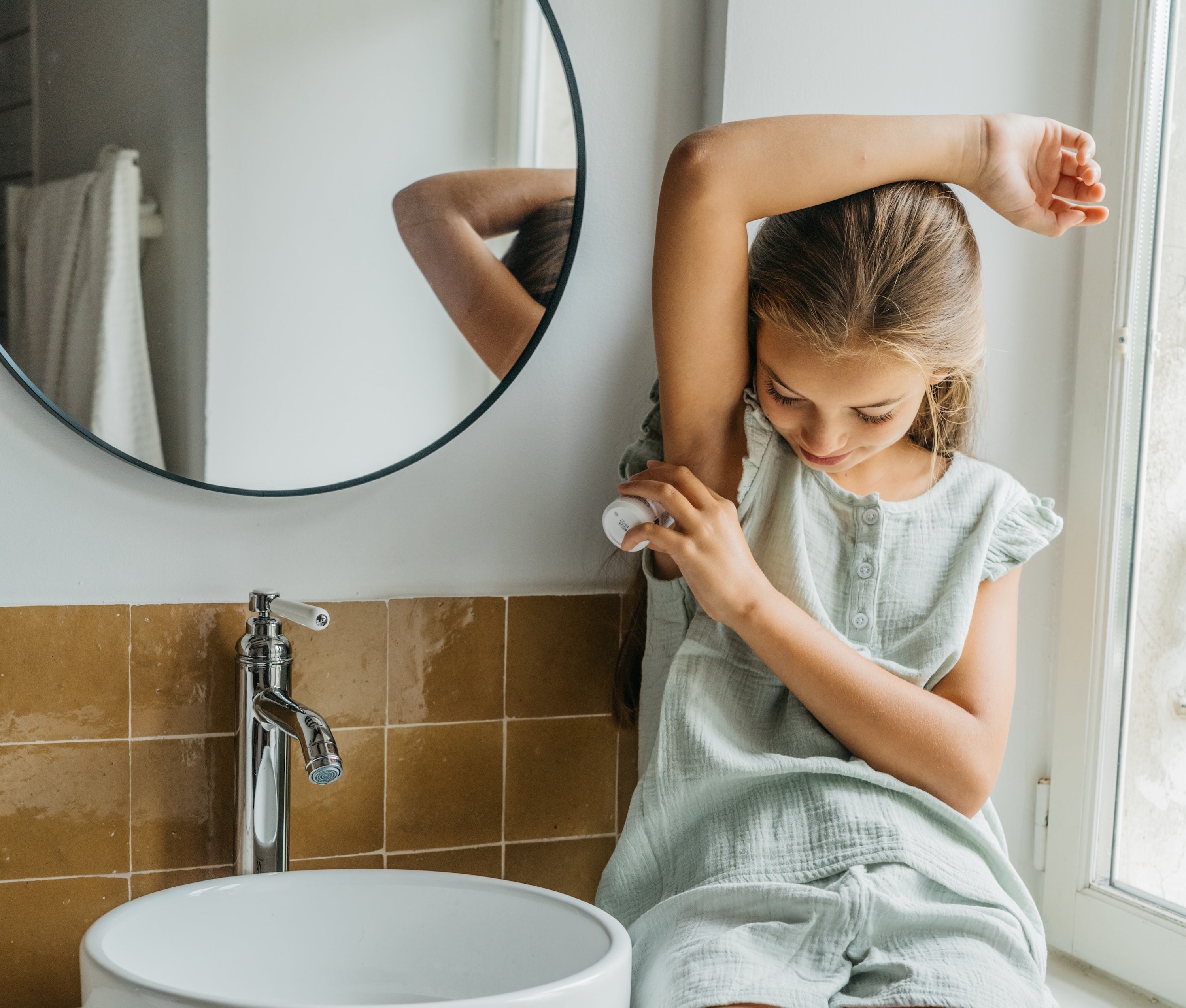young girl applying deodorant
