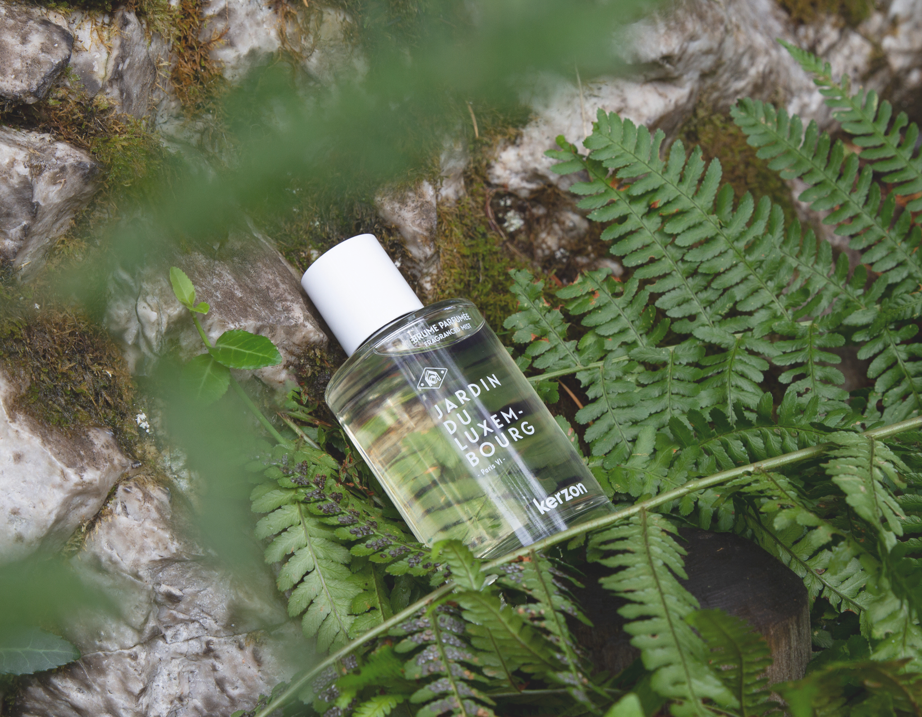 Bottle of Kerzon perfume on a rock with ferns