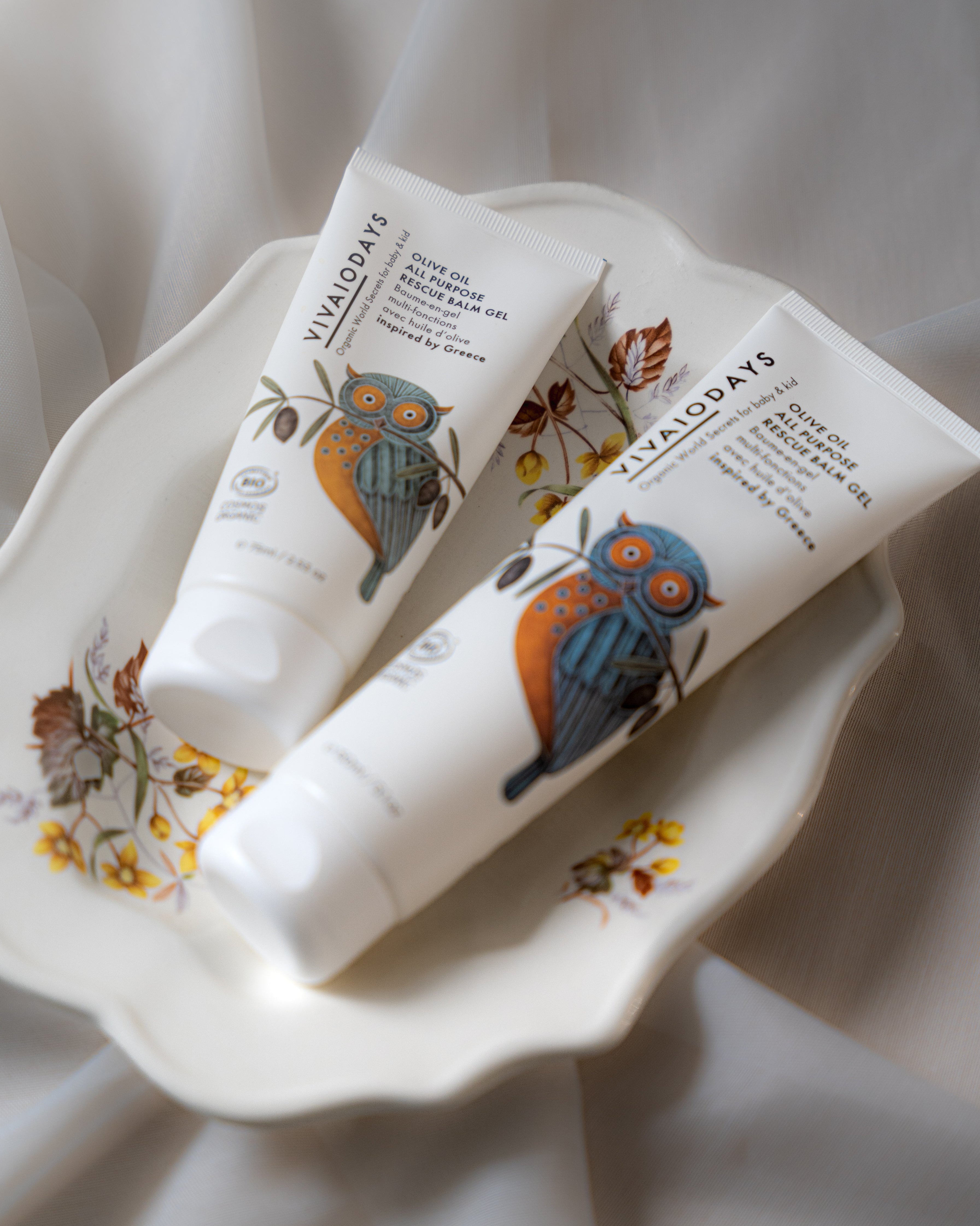 Two tubes of Vianada's skincare product on a decorative plate with a floral pattern.