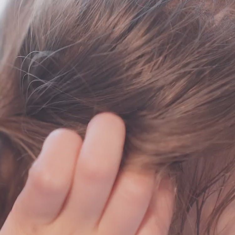 a girl washing her hair with toofruit shampoo
