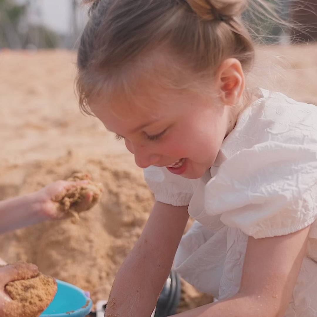 a video of two girls playing at the beach and using toofruit after sun gel after