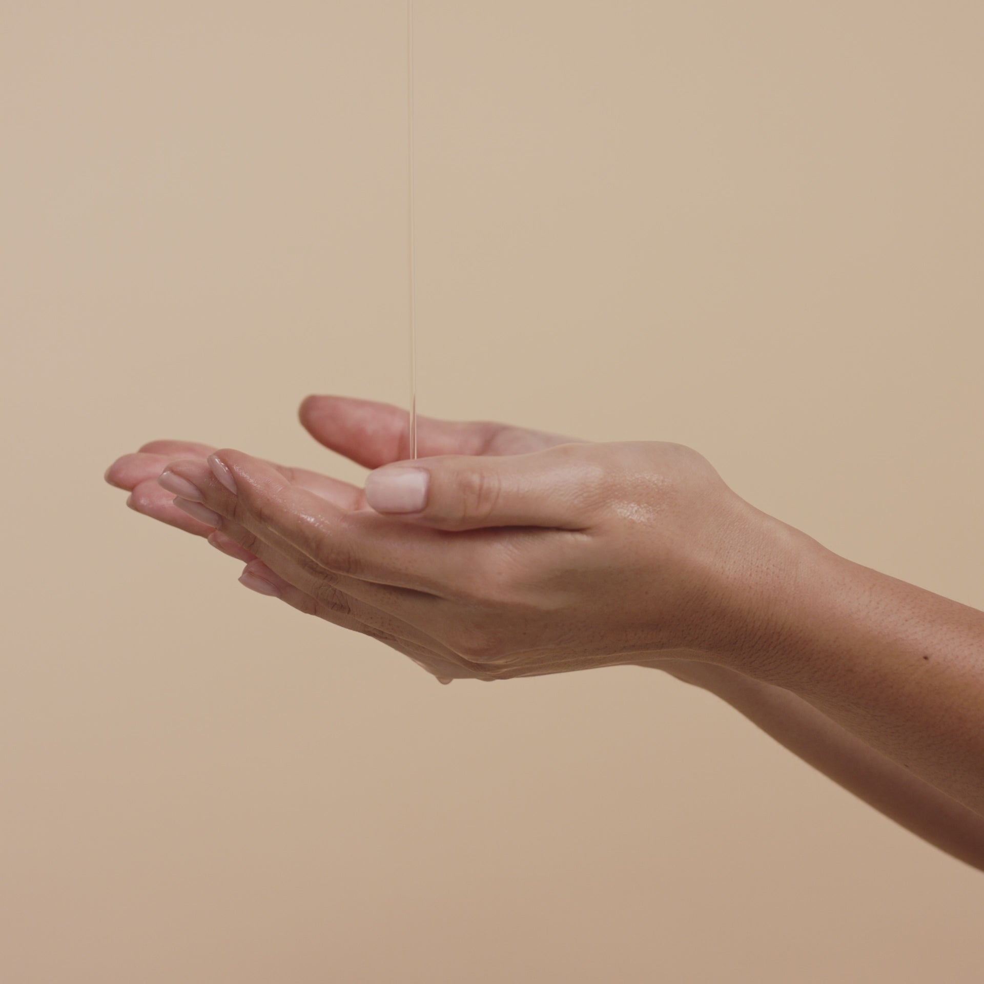 a pair of hands receiving saya hand wash and foaming it up 