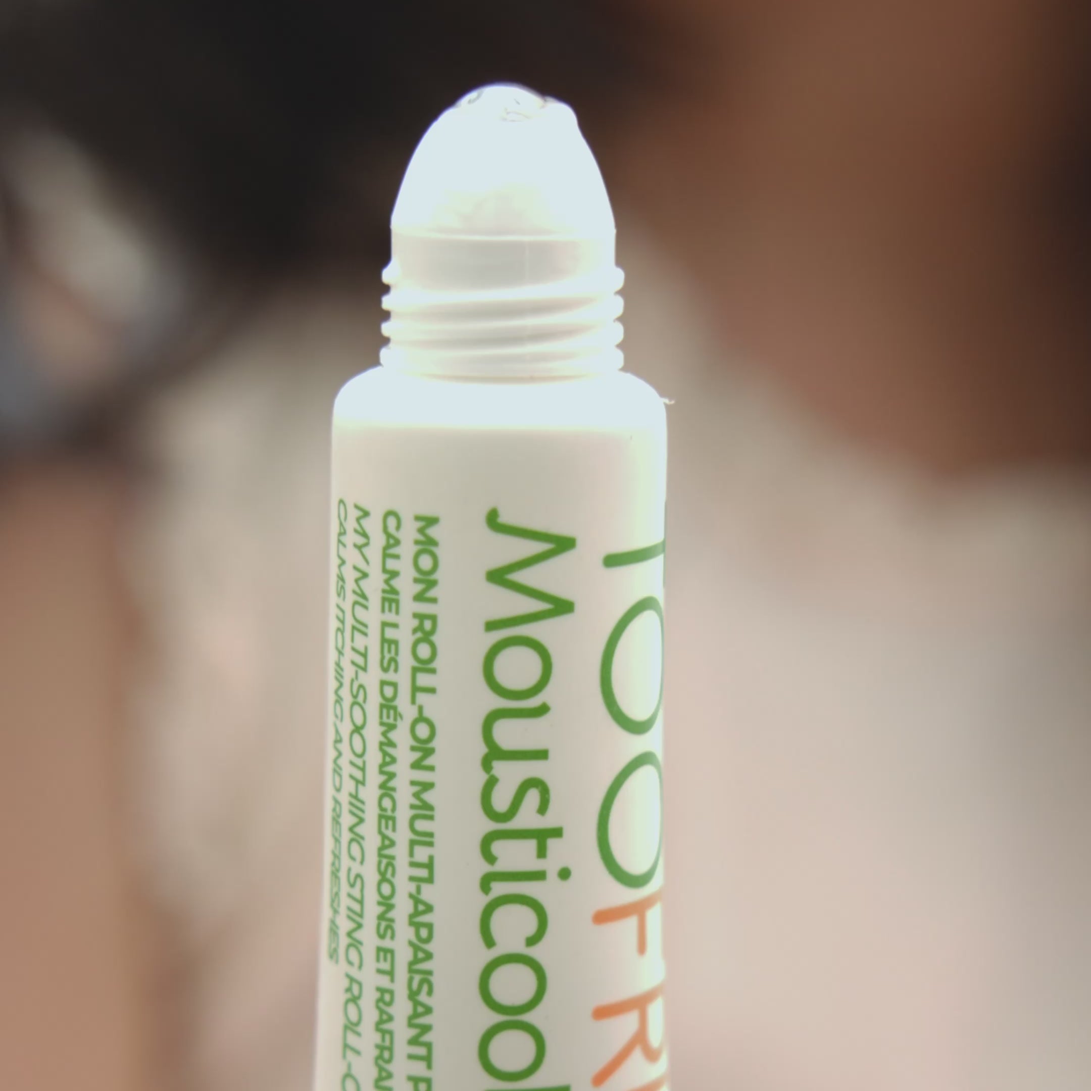 a girl using mousticool roll on on her face