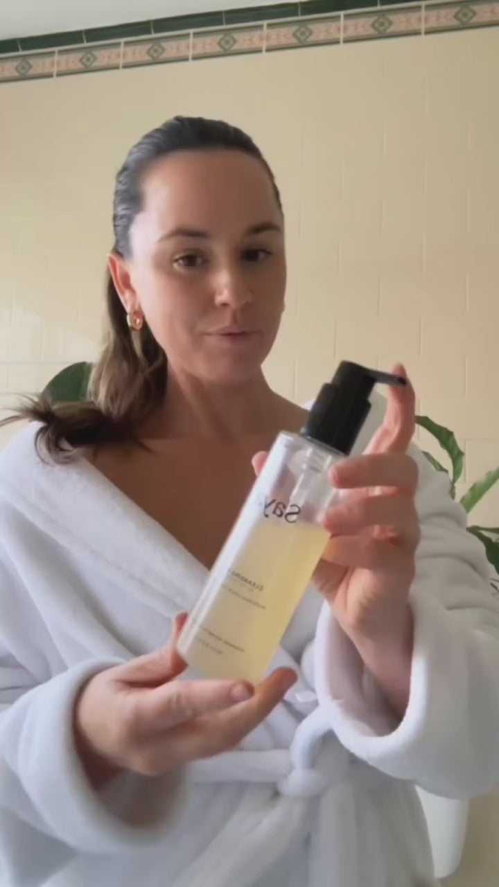 a woman using saya cleansing gel to wash her face