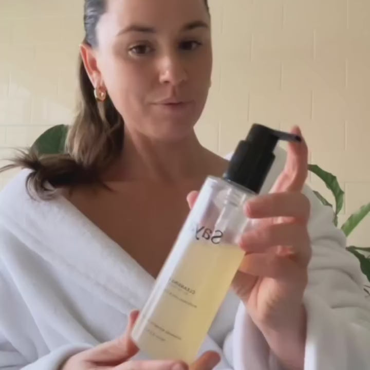 a woman using saya cleansing gel to wash her face
