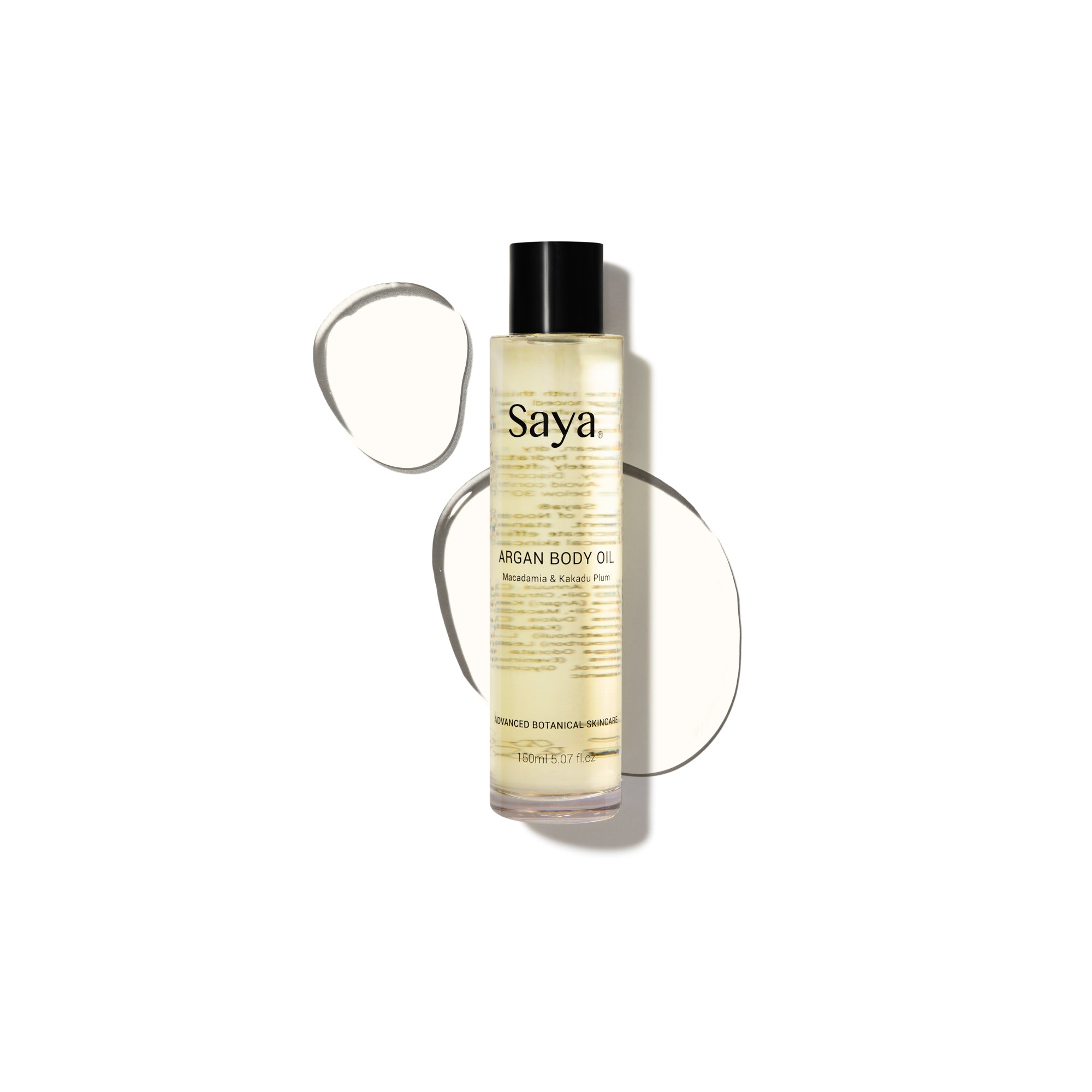 a bottle of saya argan body oil laying on a puddle of oil