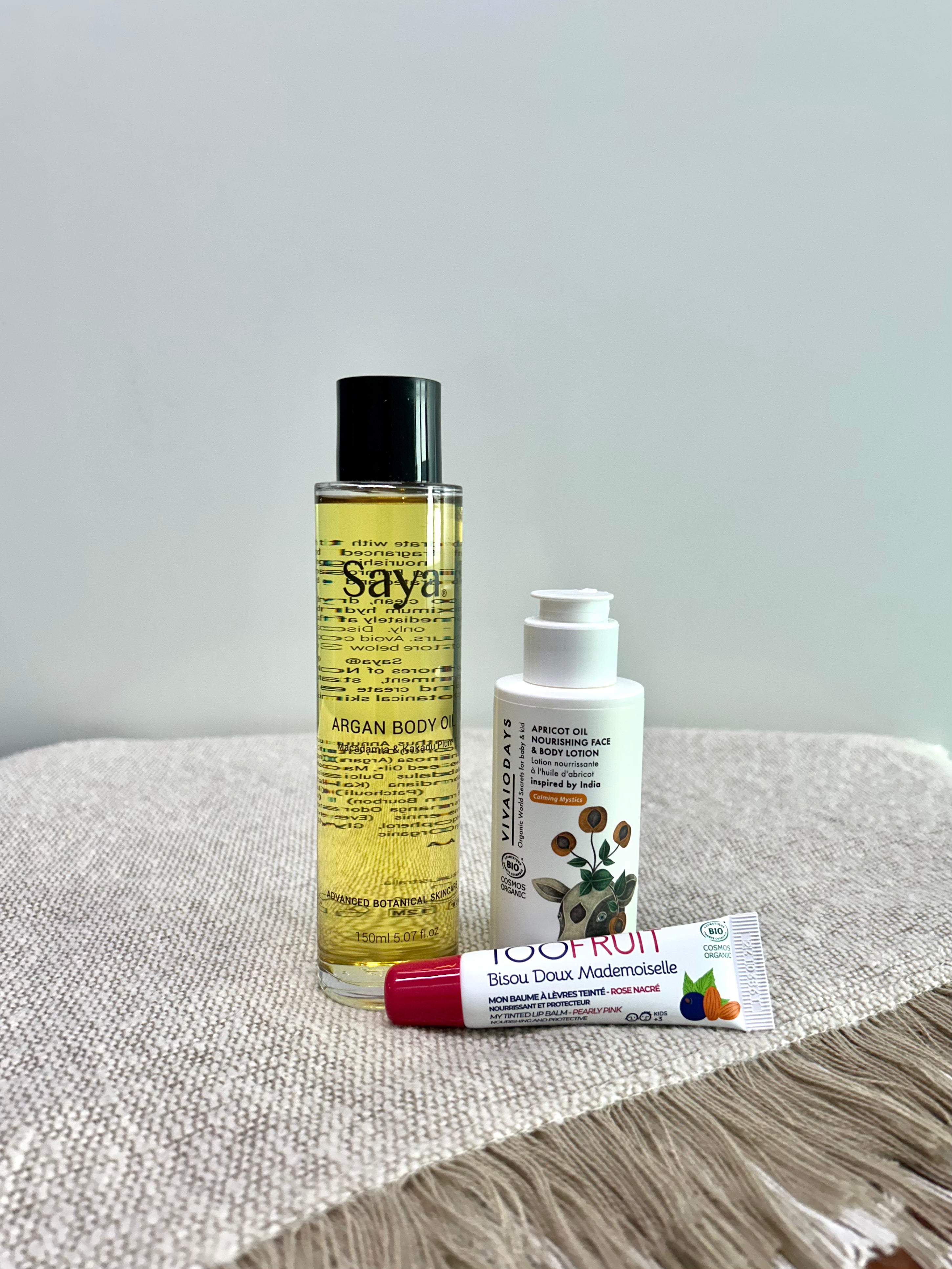 argan body oil, apricot lotion and tinted lipbalm on a table