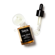 an opened bottle of saya glow serum with dropper beside it