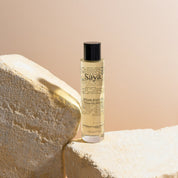 a bottle of saya argan body oil on a rock
