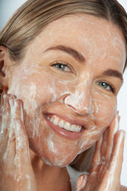 a woman washing her face with saya cleansing gel
