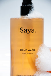a bottle of saya hand wash with foam around it 
