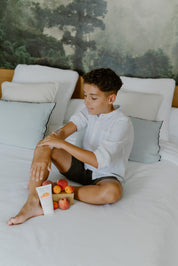 a boy applying toofruit creme bodydoux on his arm