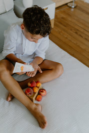 a boy squeezing toofruit creme bodydoux on his palm