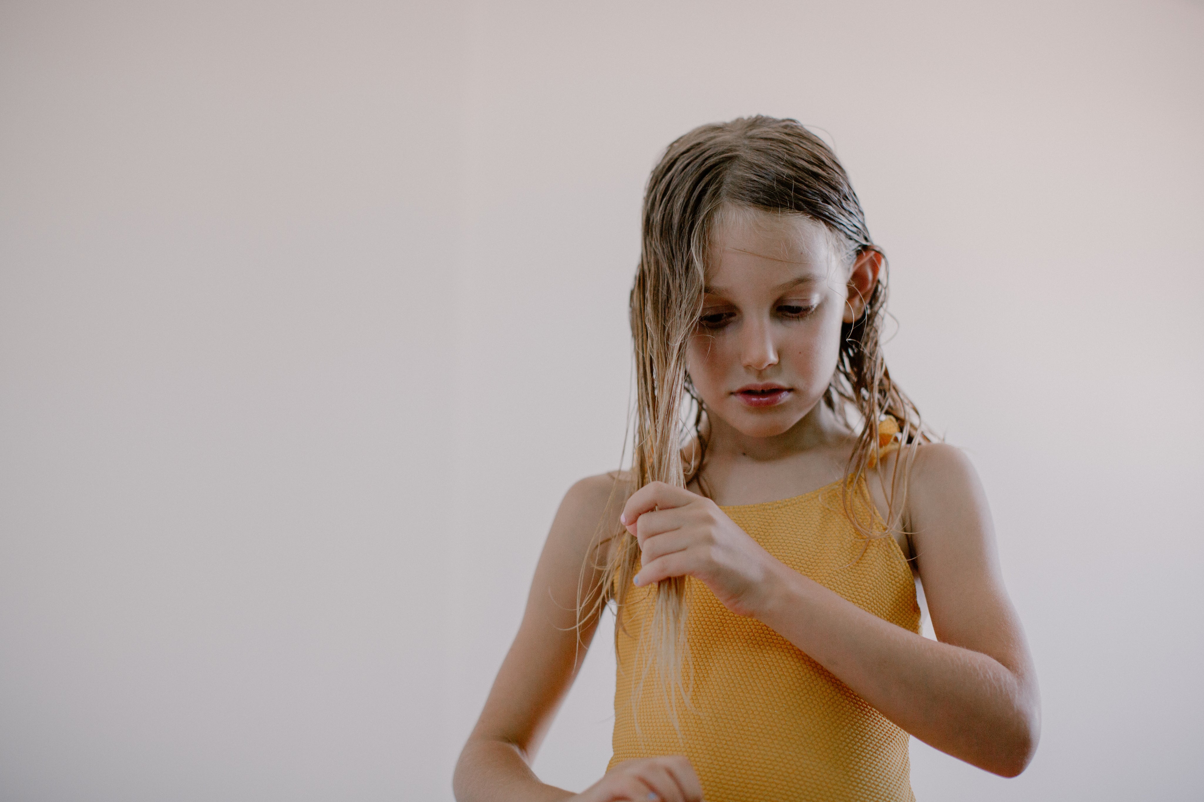 a girl combing her wet hair 