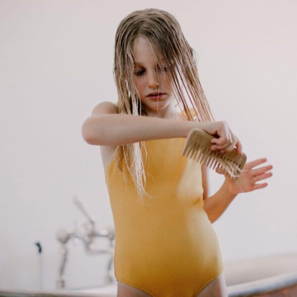 a girl combing her wet hair 
