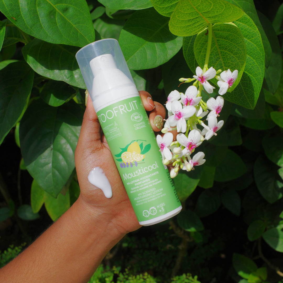 a hand holding a bottle of toofruit mousticool lotion