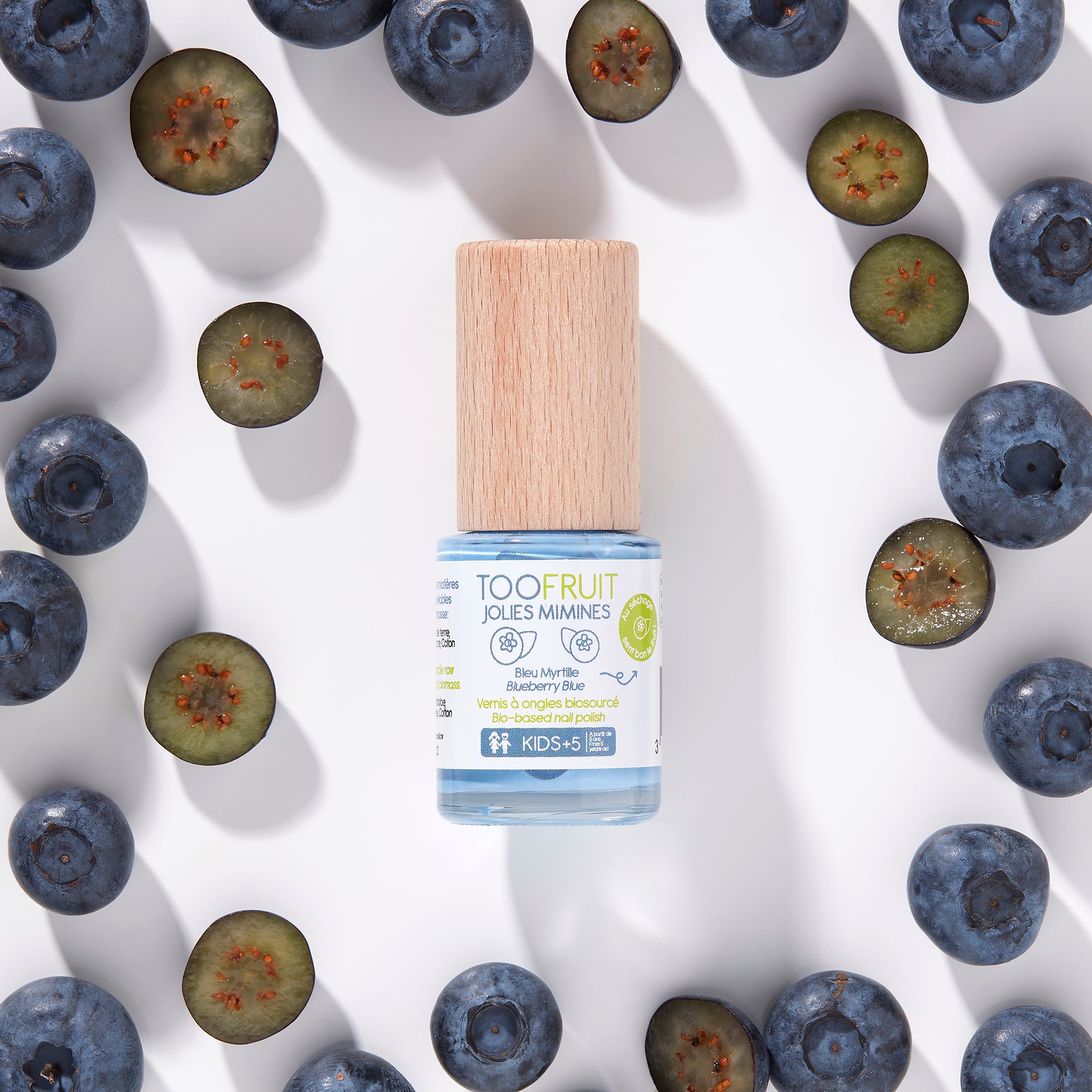 a bottle of toofruit blueberry nail polish and blueberries