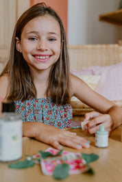 a girl smiling while applying toofruit nail polish on her nails