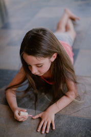 a girl painting her nails pink