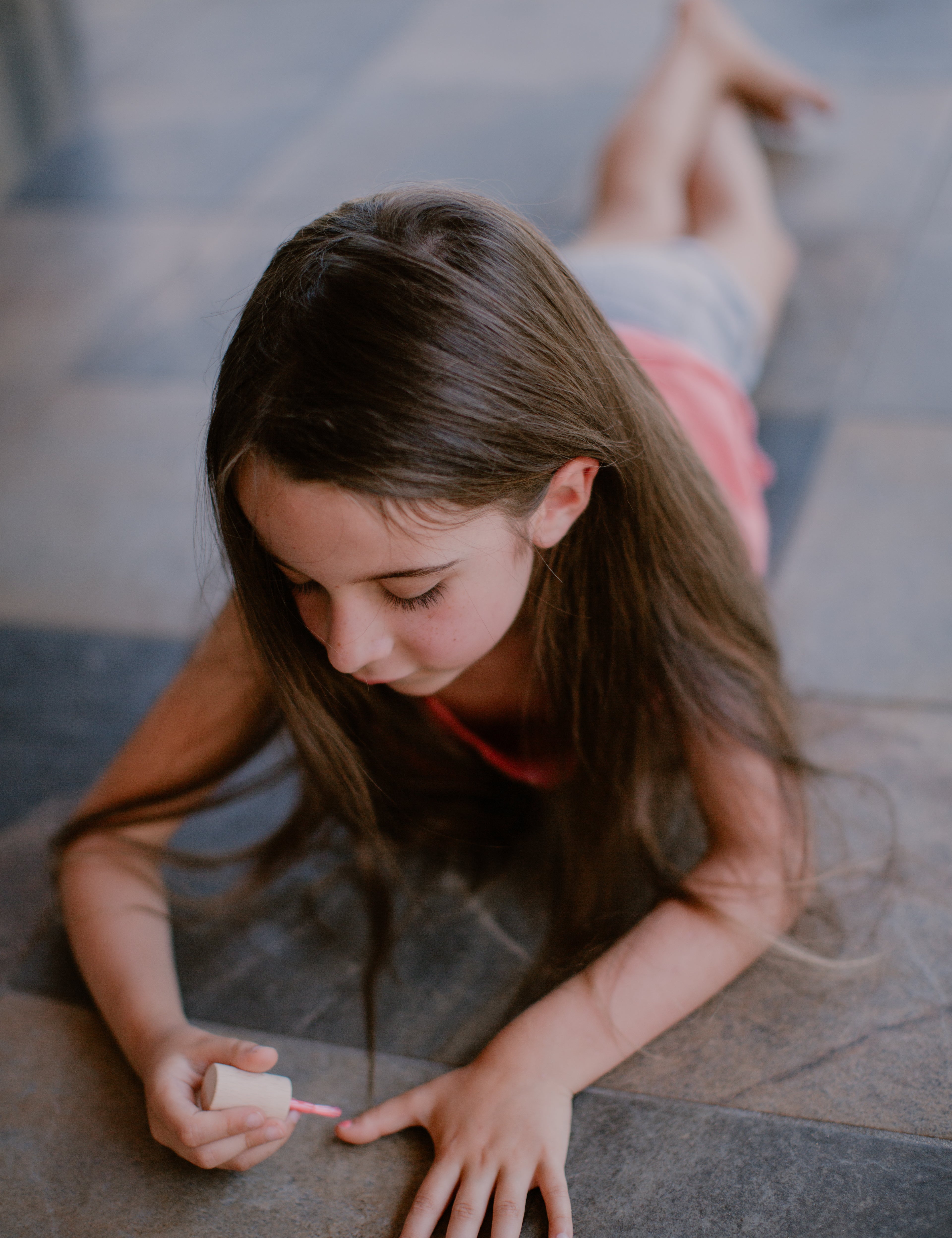 a girl painting her nails pink