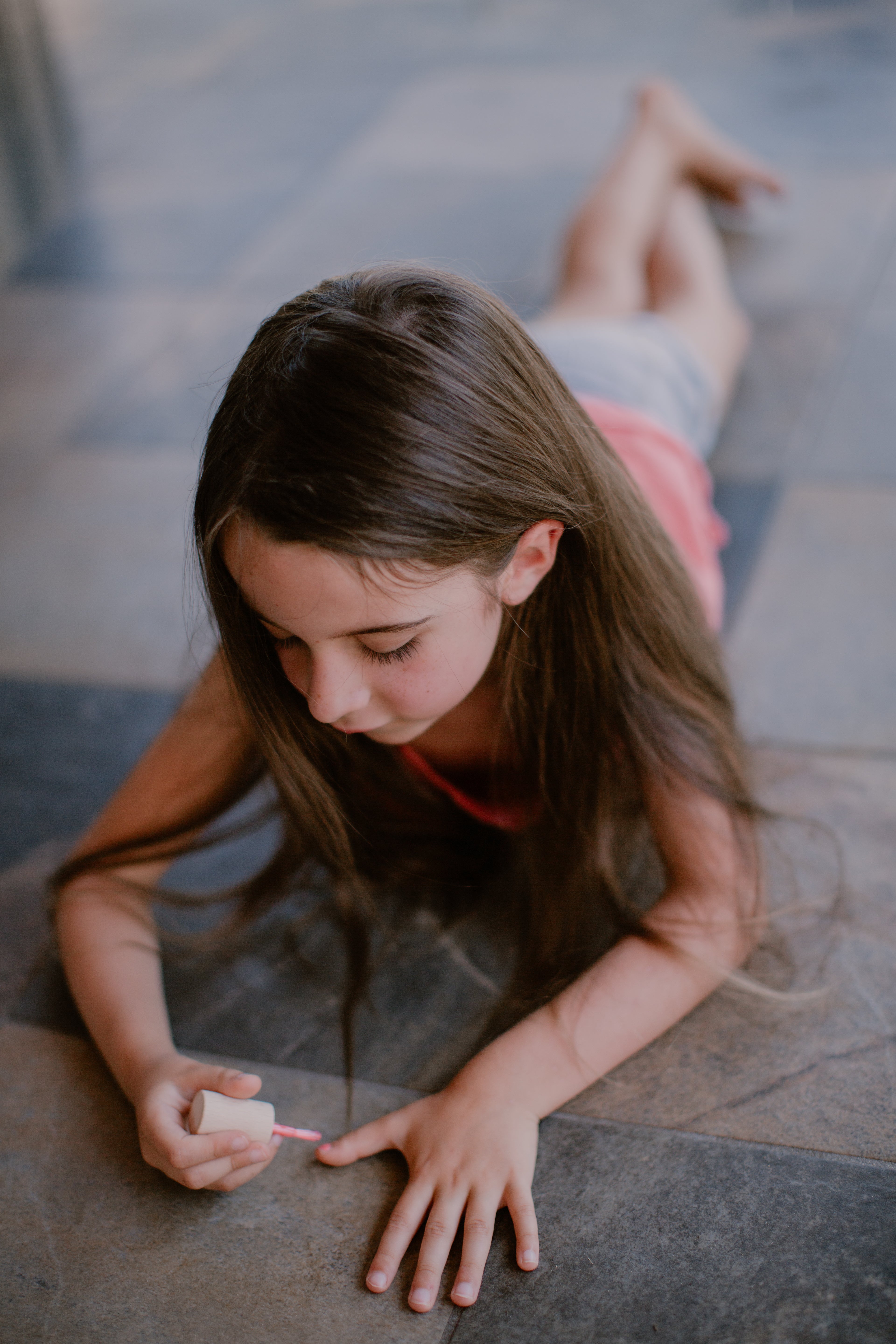 a girl painting her nails pink