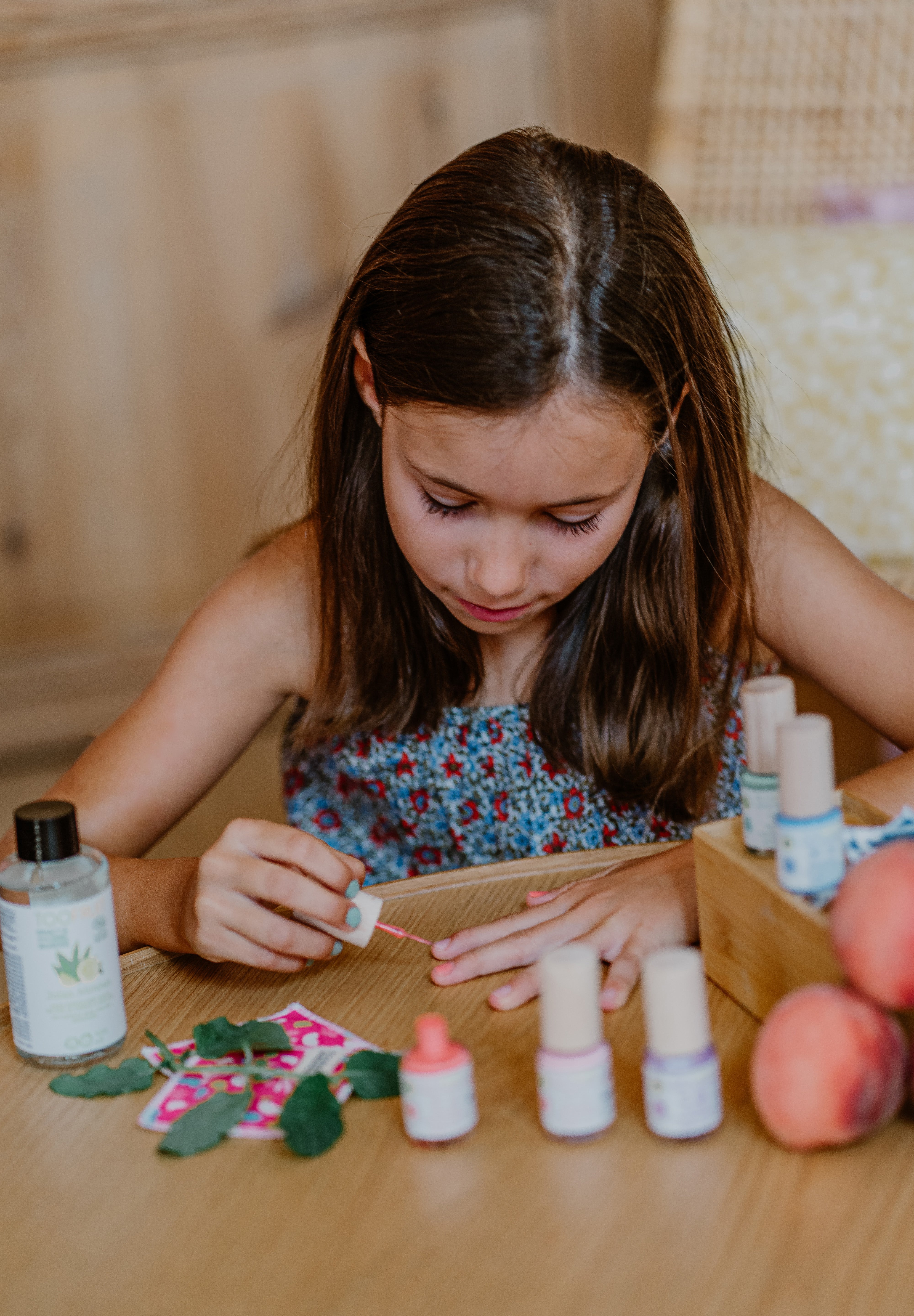 a girl applying toofruit nail polish on her nails
