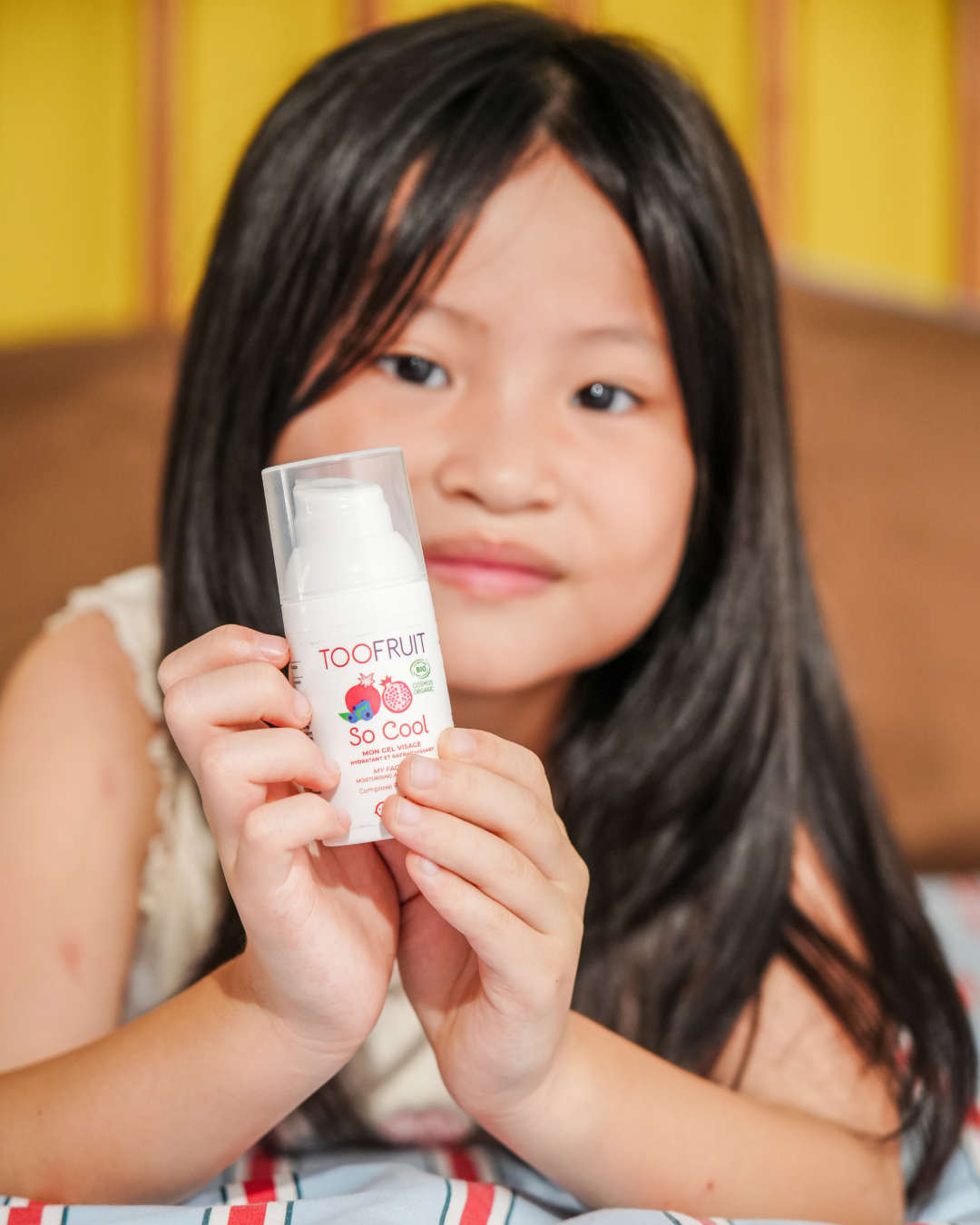 a girl holding a bottle of toofruit so cool face gel