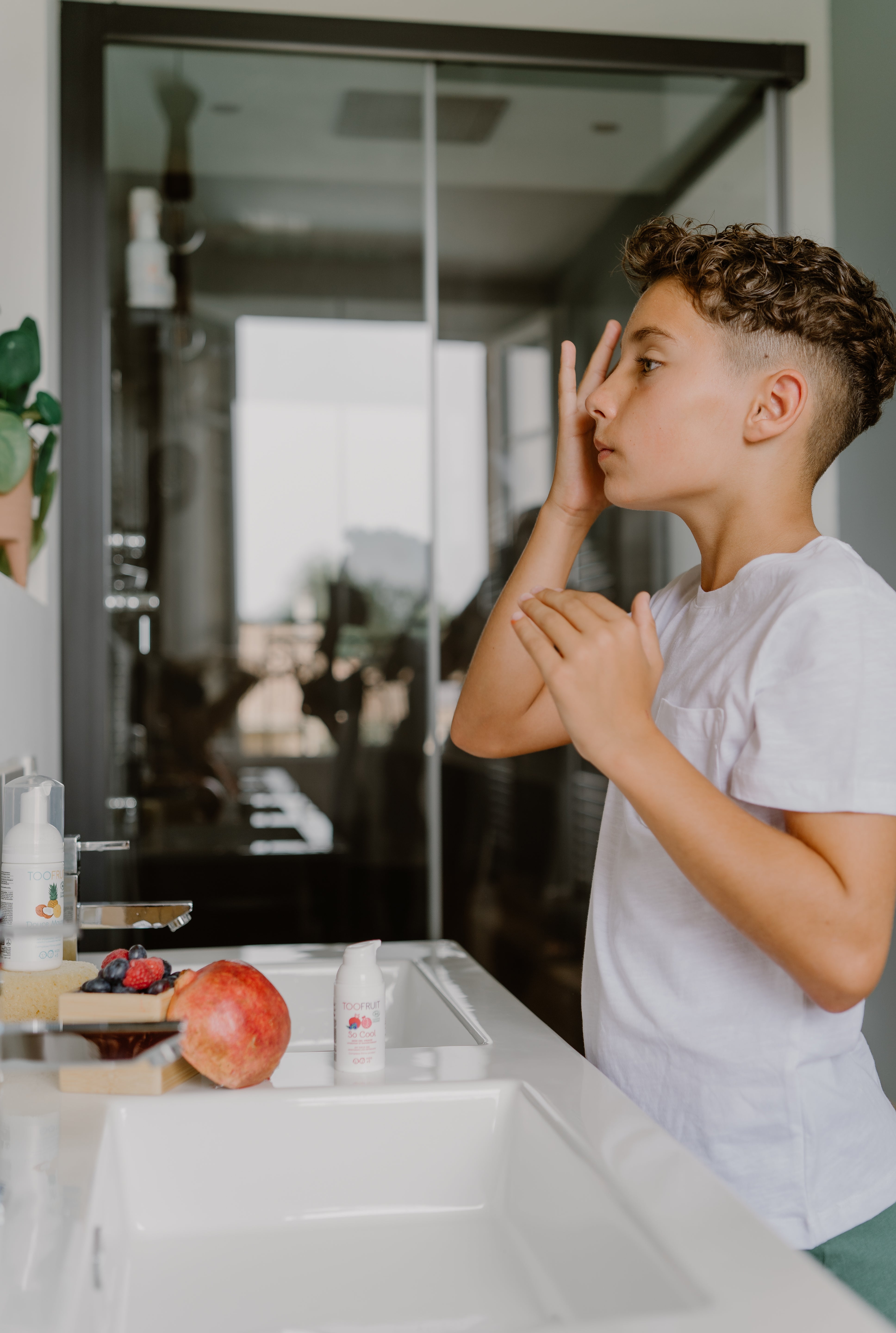 a boy applying toofruit so cool on his face