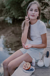 a girl applying toofruit so cool on her face
