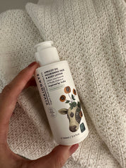 a hand holding a bottle of vivaiodays fragrance free apricot oil face and body lotion