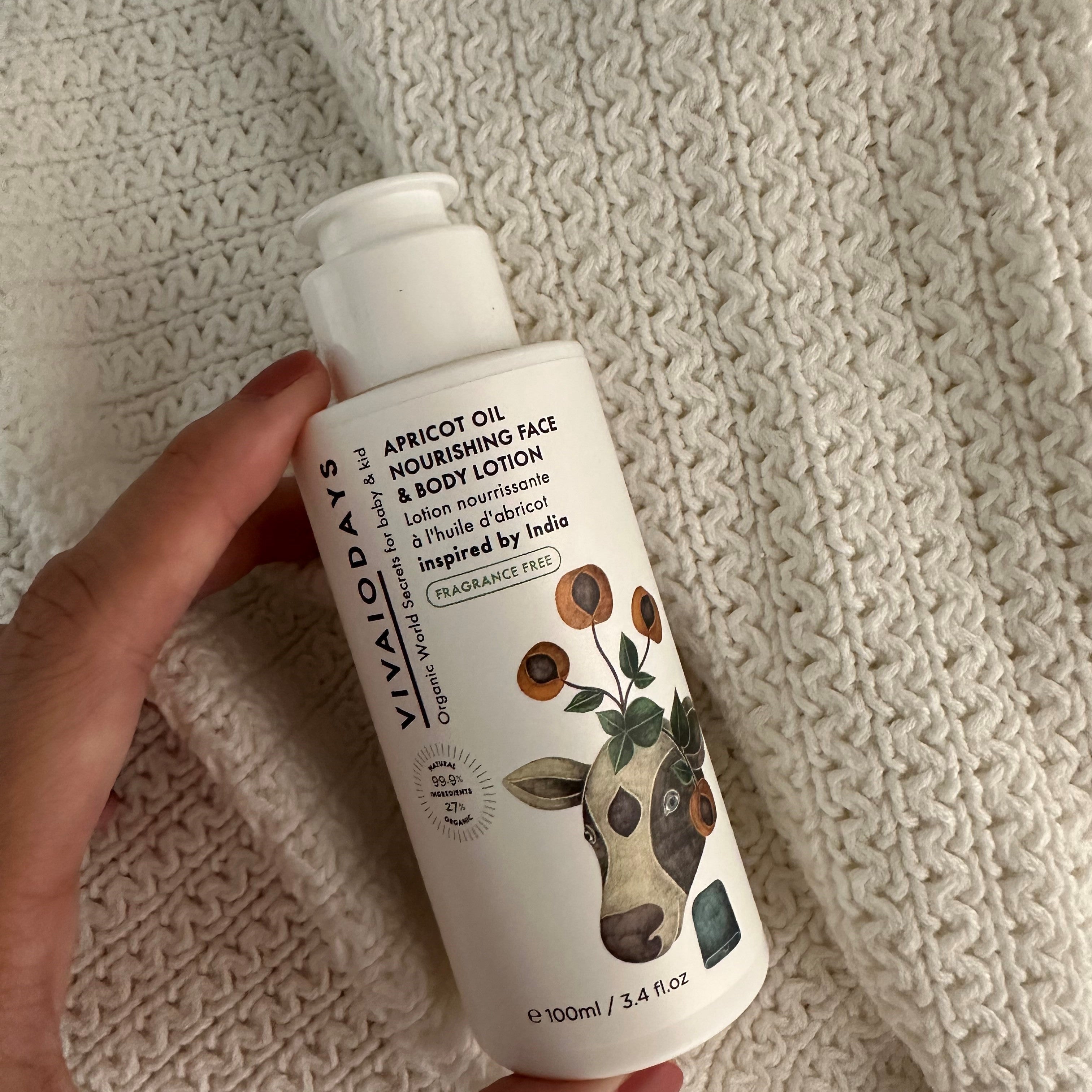 a hand holding a bottle of vivaiodays fragrance free apricot oil face and body lotion