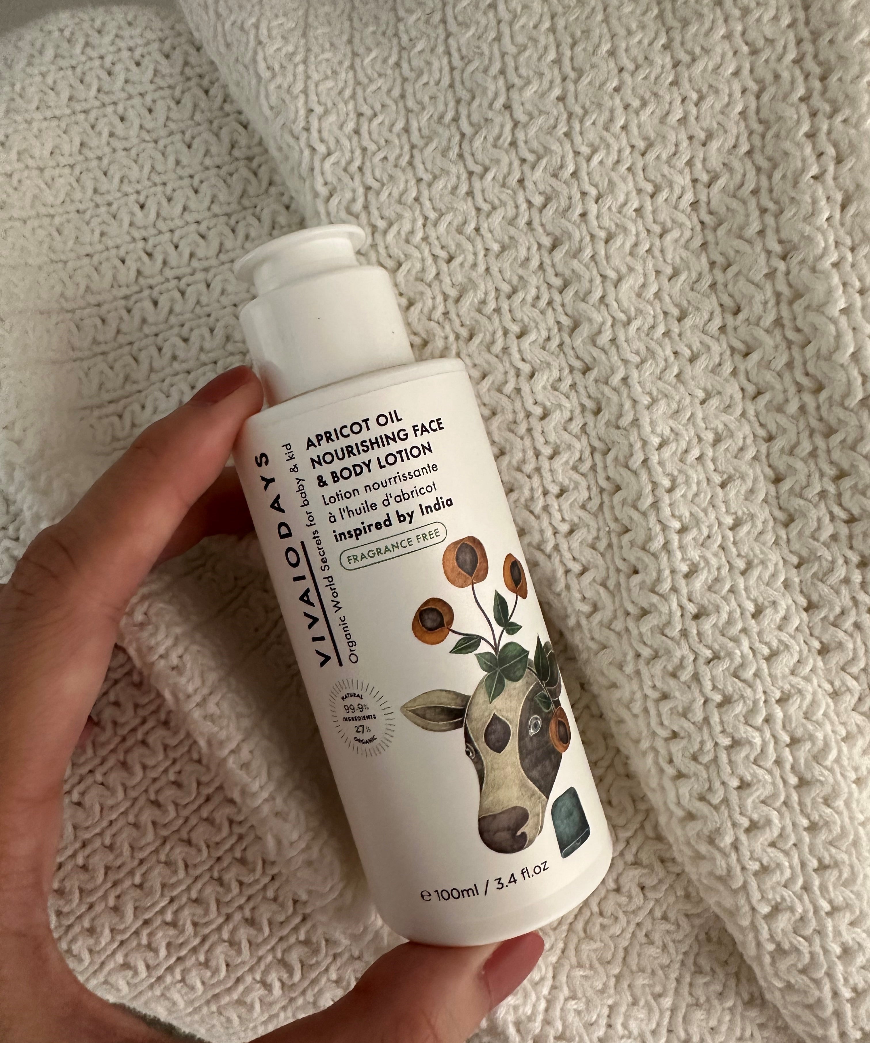 a hand holding a bottle of vivaiodays fragrance free apricot oil face and body lotion