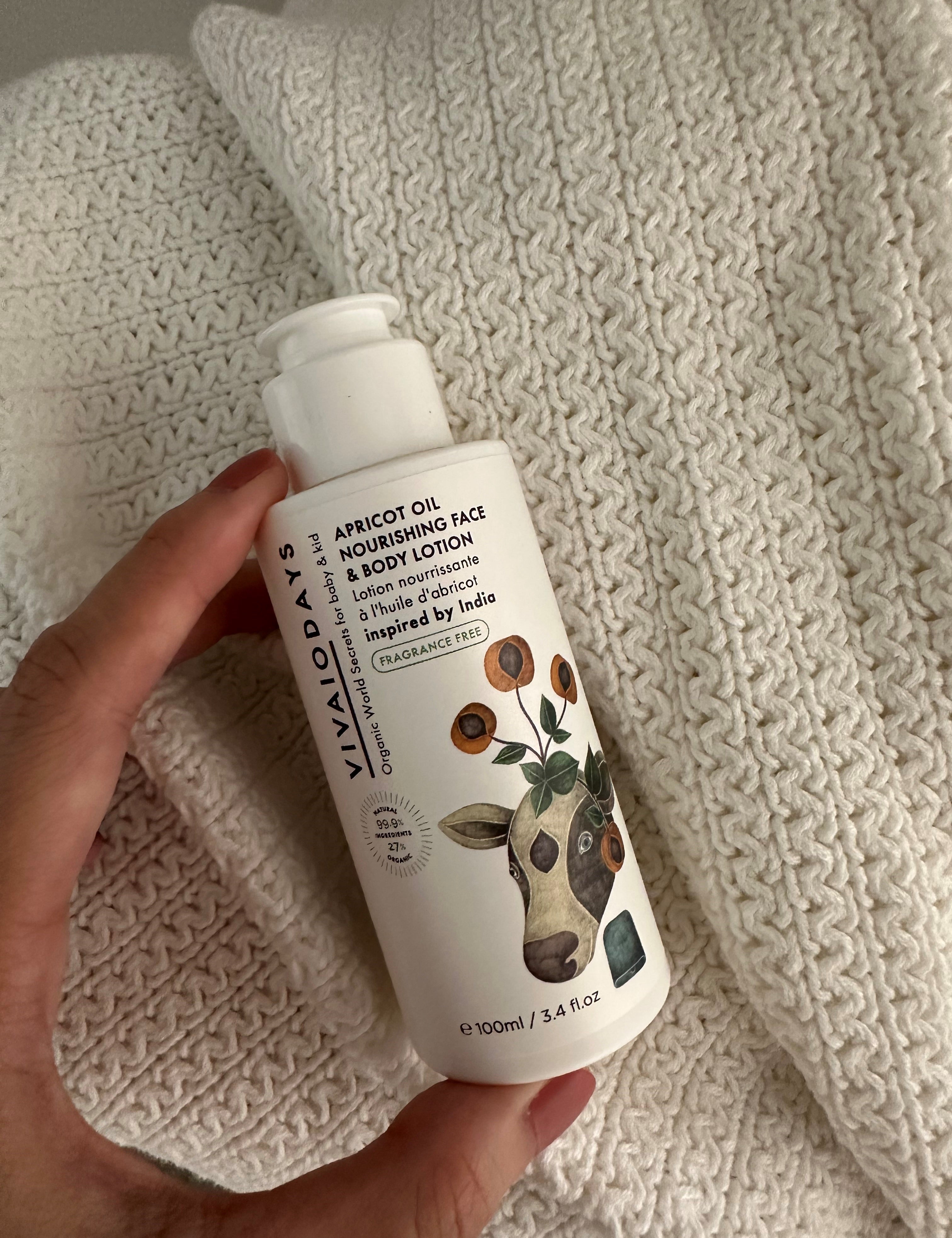 a hand holding a bottle of vivaiodays fragrance free apricot oil face and body lotion