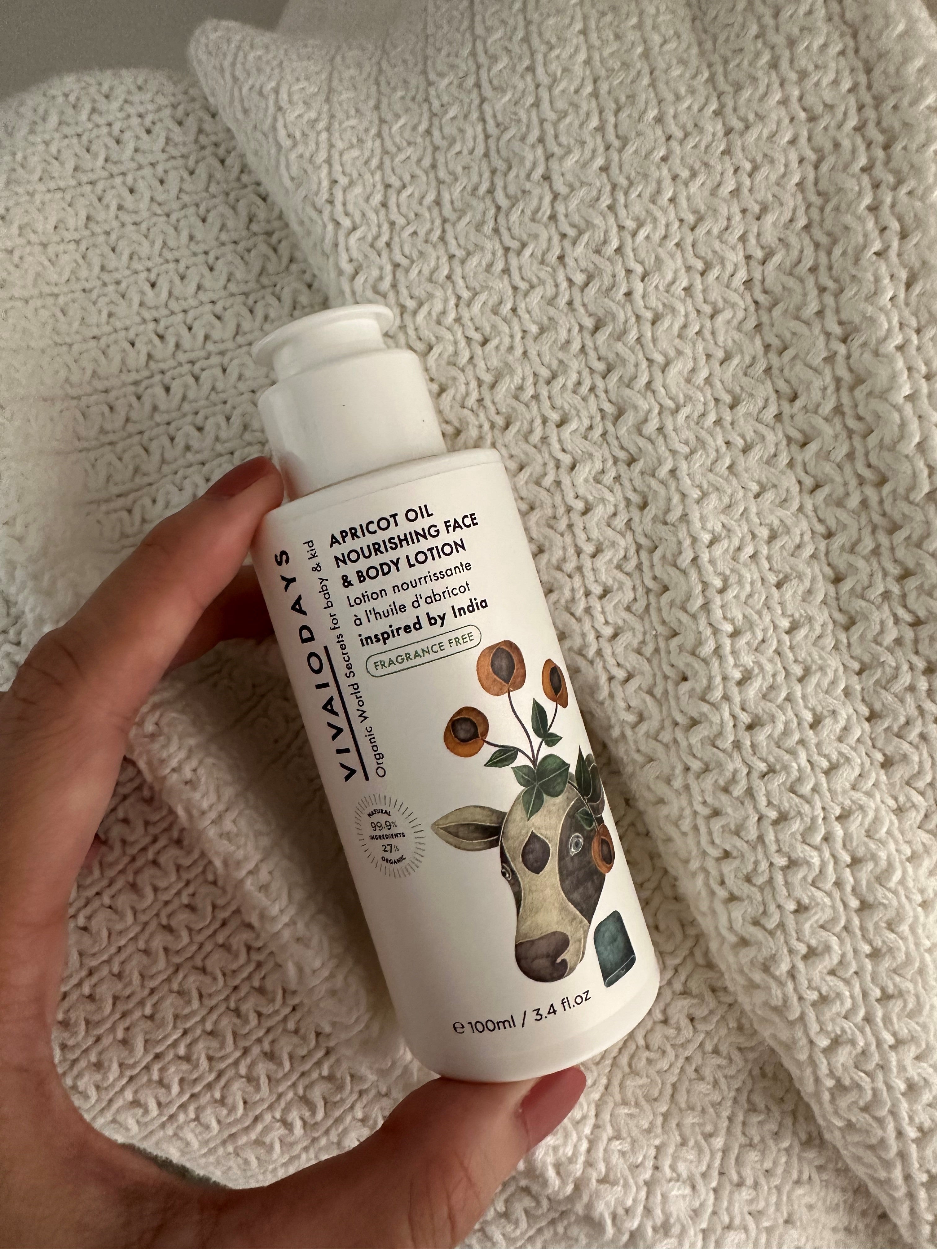 a hand holding a bottle of vivaiodays fragrance free apricot oil face and body lotion