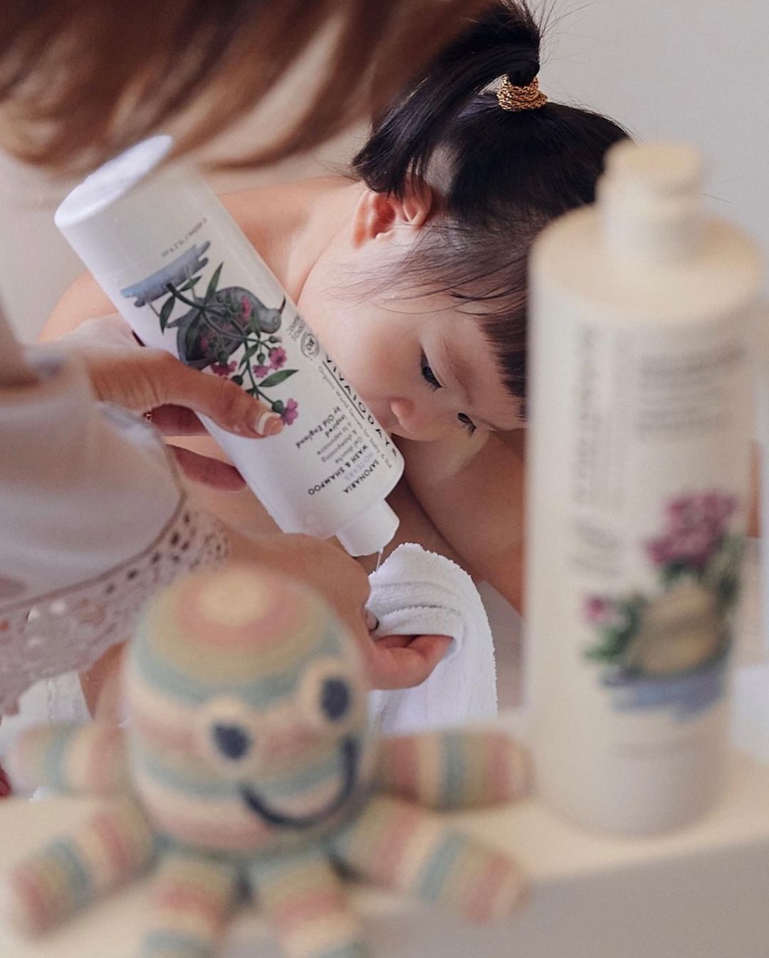 a woman squeezing a bottle of saponaria shampoo onto a towel