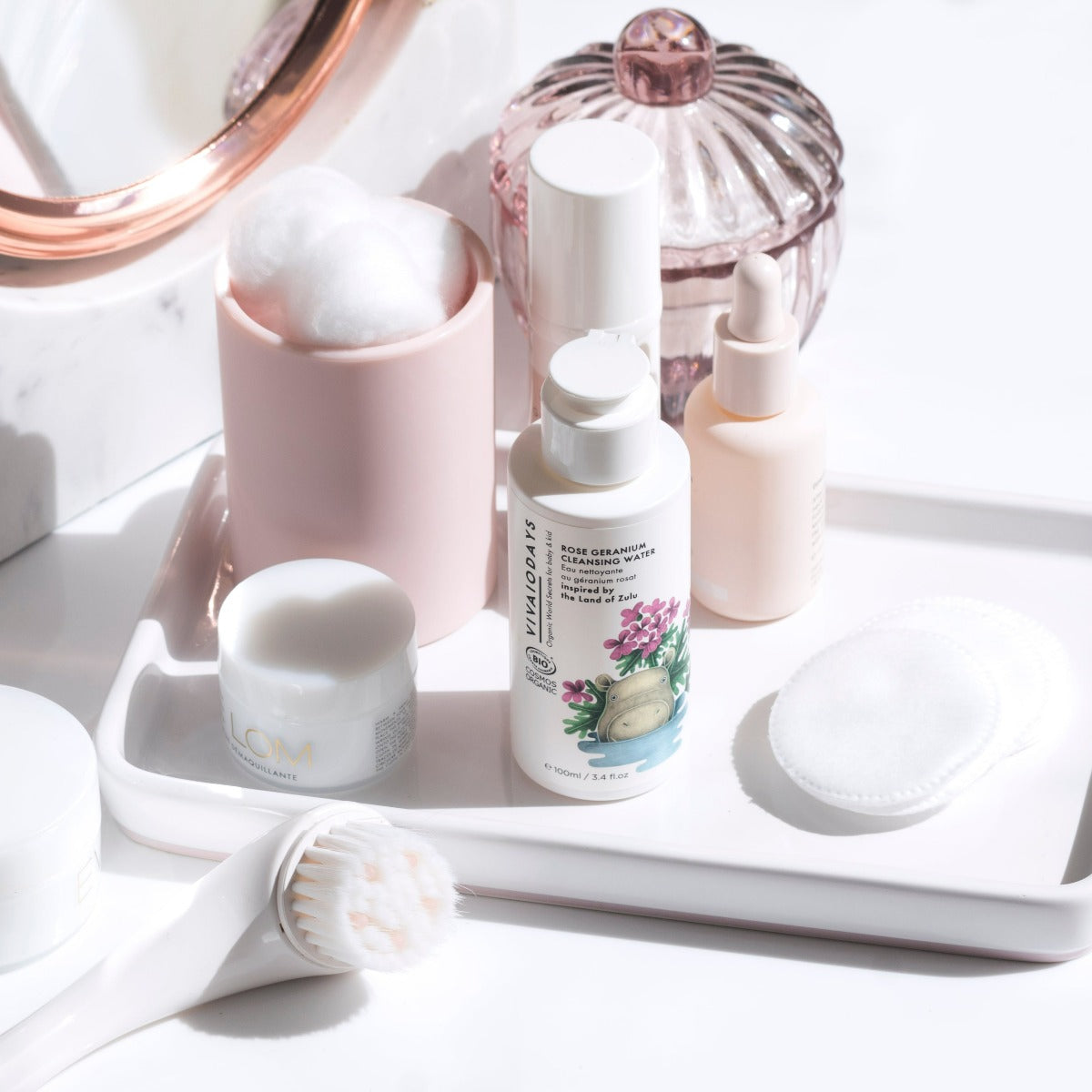 a bottle of vivaiodays rose geranium micellar cleansing water on a tray of skincare items