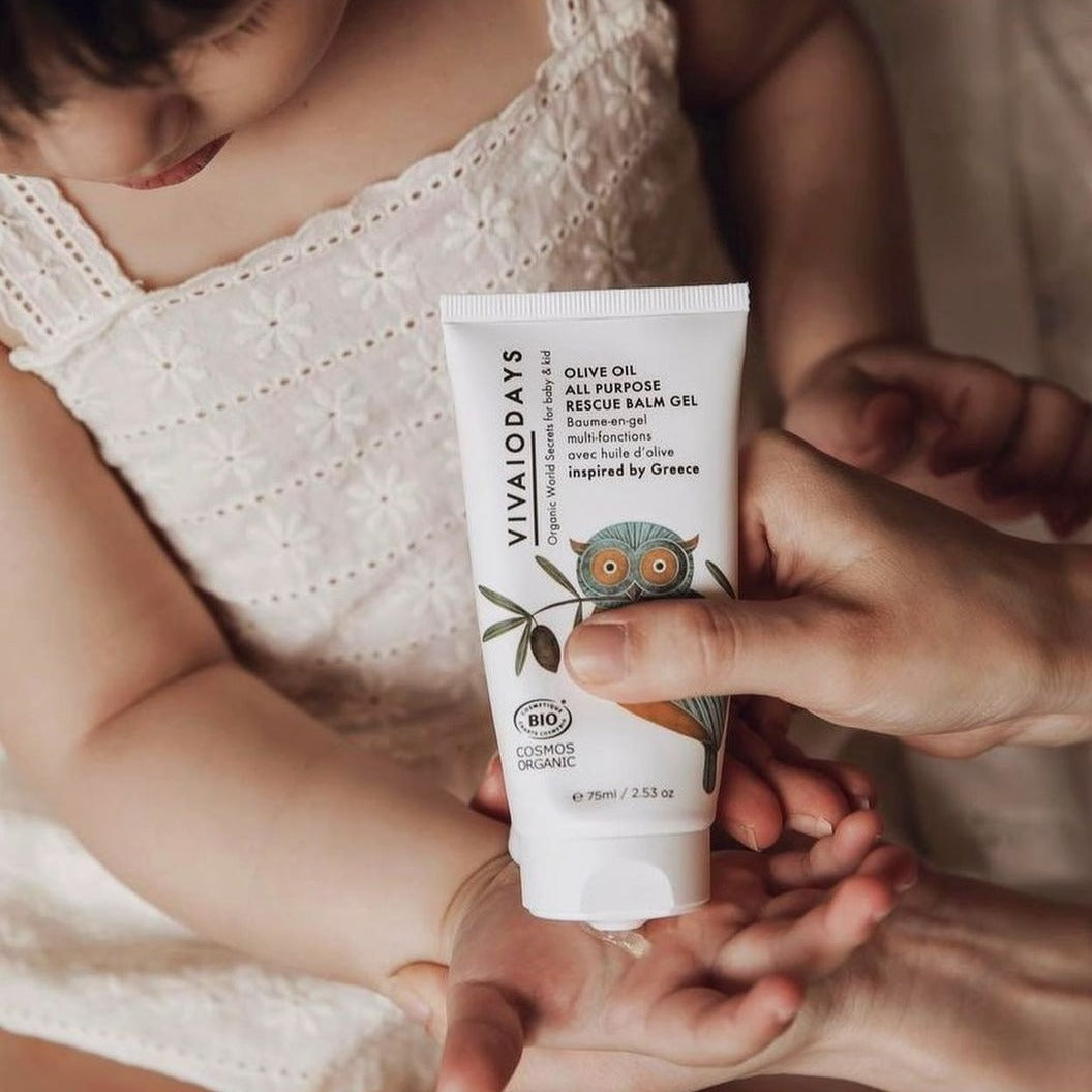 a person squeezing olive oil balm gel on a girl's hand